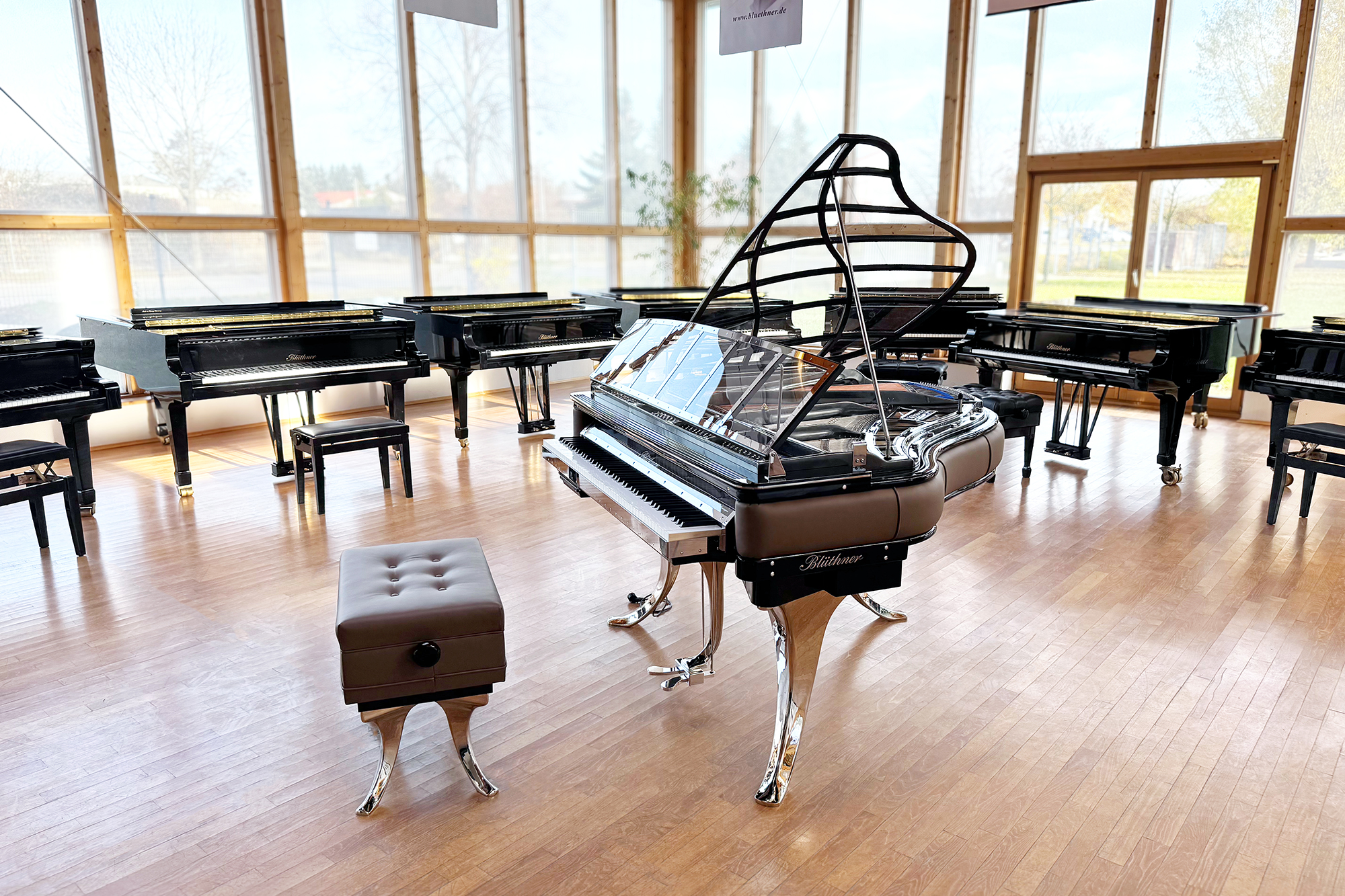 Original Blüthner PH Piano 150cm with brown leather, chrome metal fittings and a black iron frame.