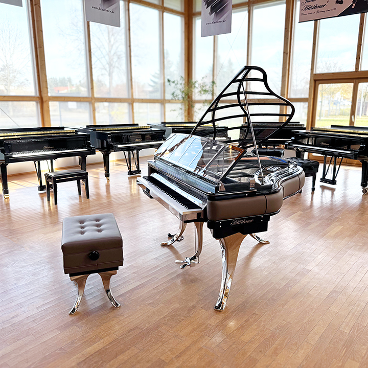 Original Blüthner PH Piano 150cm with brown leather, chrome metal fittings and a black iron frame.