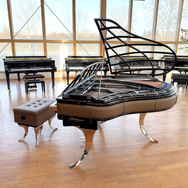 Original Blüthner PH Piano 150cm with brown leather, chrome metal fittings and a black iron frame.